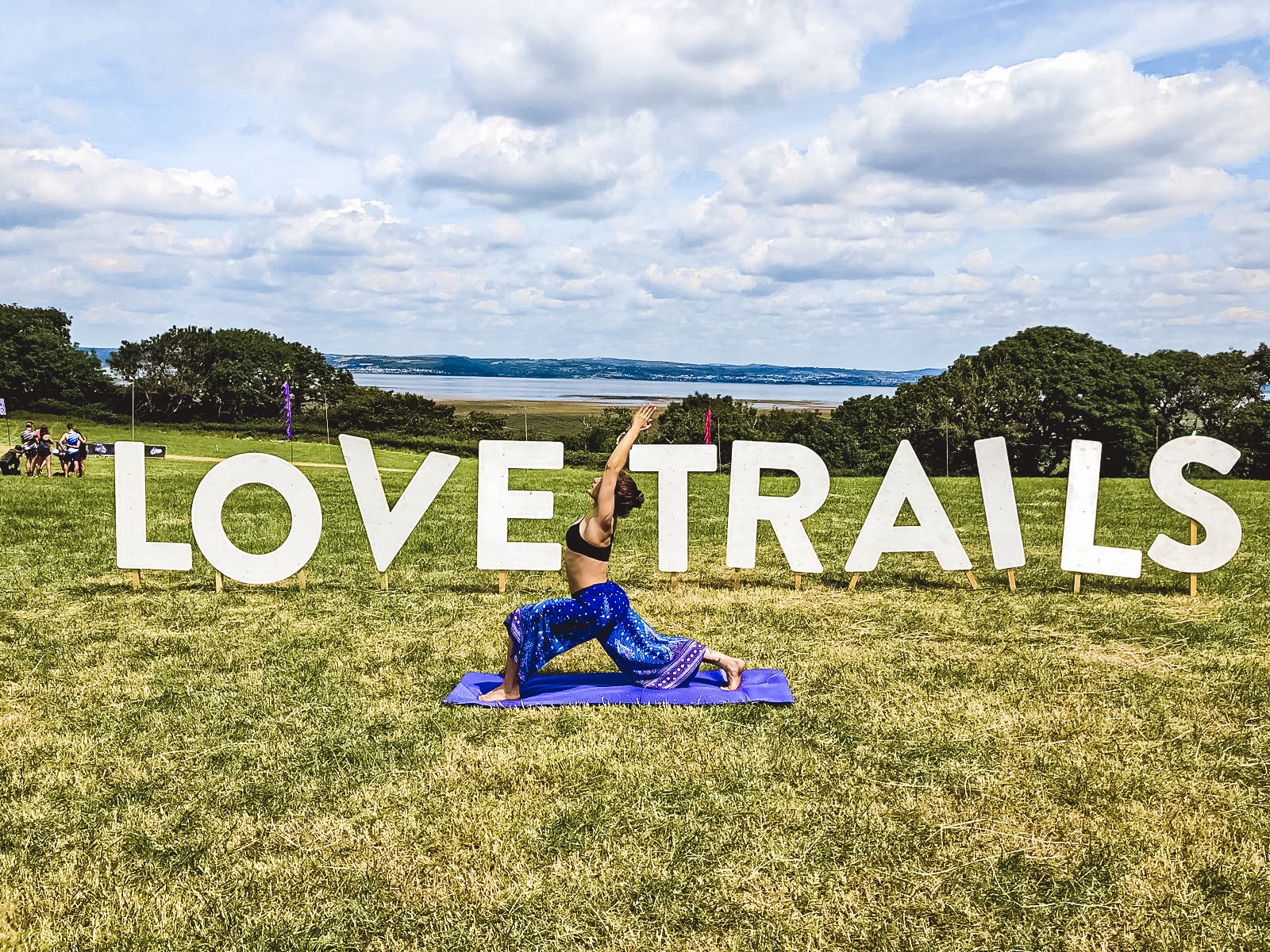 Love trails festival with girl standing in yoga pose in front of Love trails sign